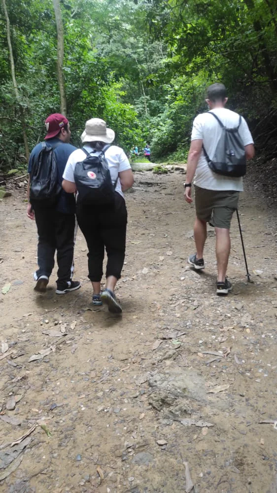 Senderistas avanzando por un tramo de tierra, piedras y pendiente durante la subida al cerro El Ávila en Caracas