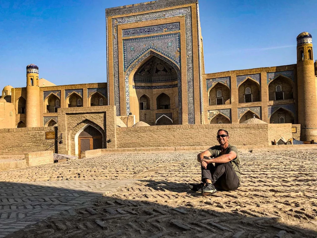 Felipe sentado sobre el muro de un edificio en la ciudad vieja de Jiva en su viaje a Uzbekistan con discacidad visual
